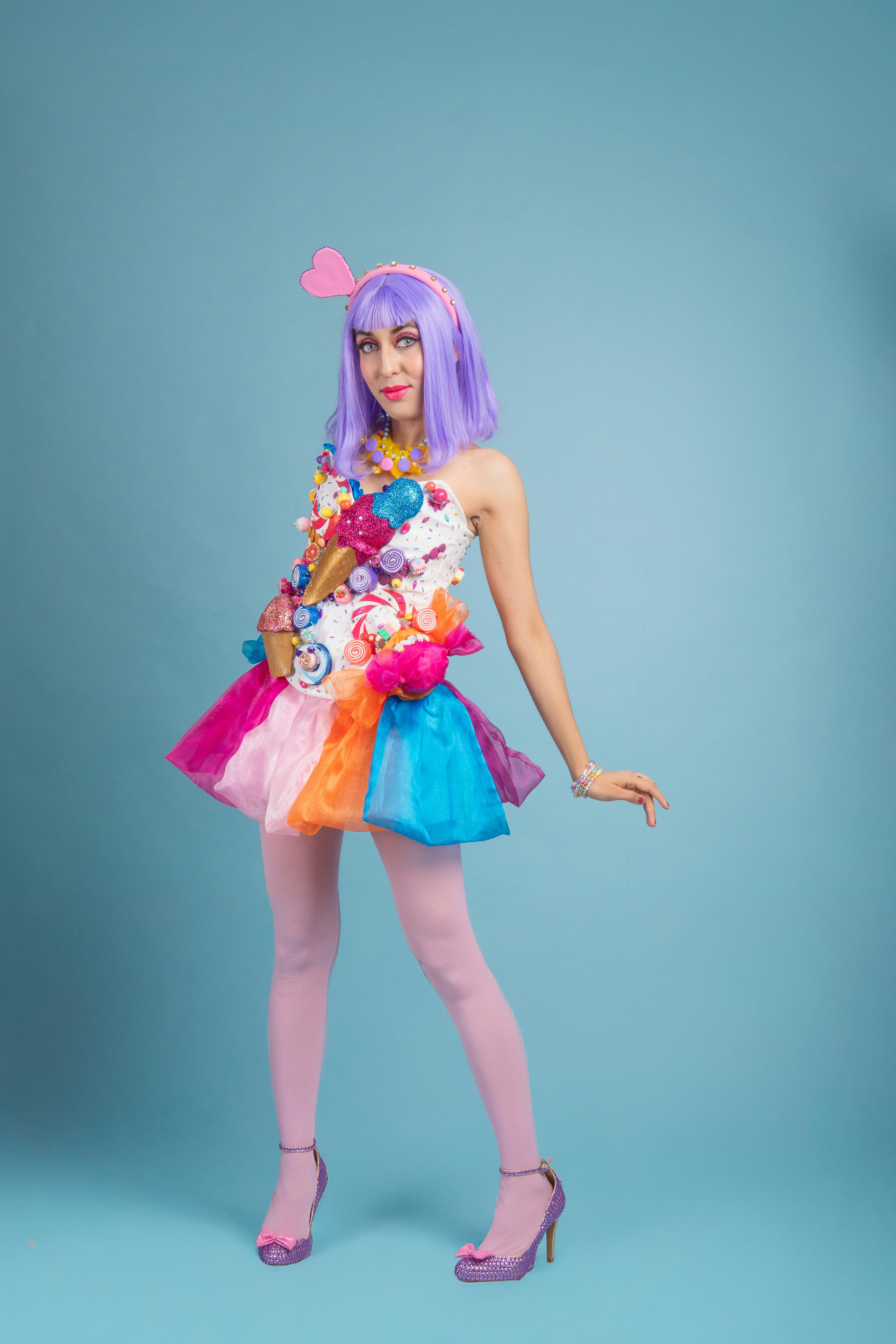 ingyenes Színes cosplay portré, amelyen egy nő látható élénk ruhában, kék háttér előtt. Stockfotó