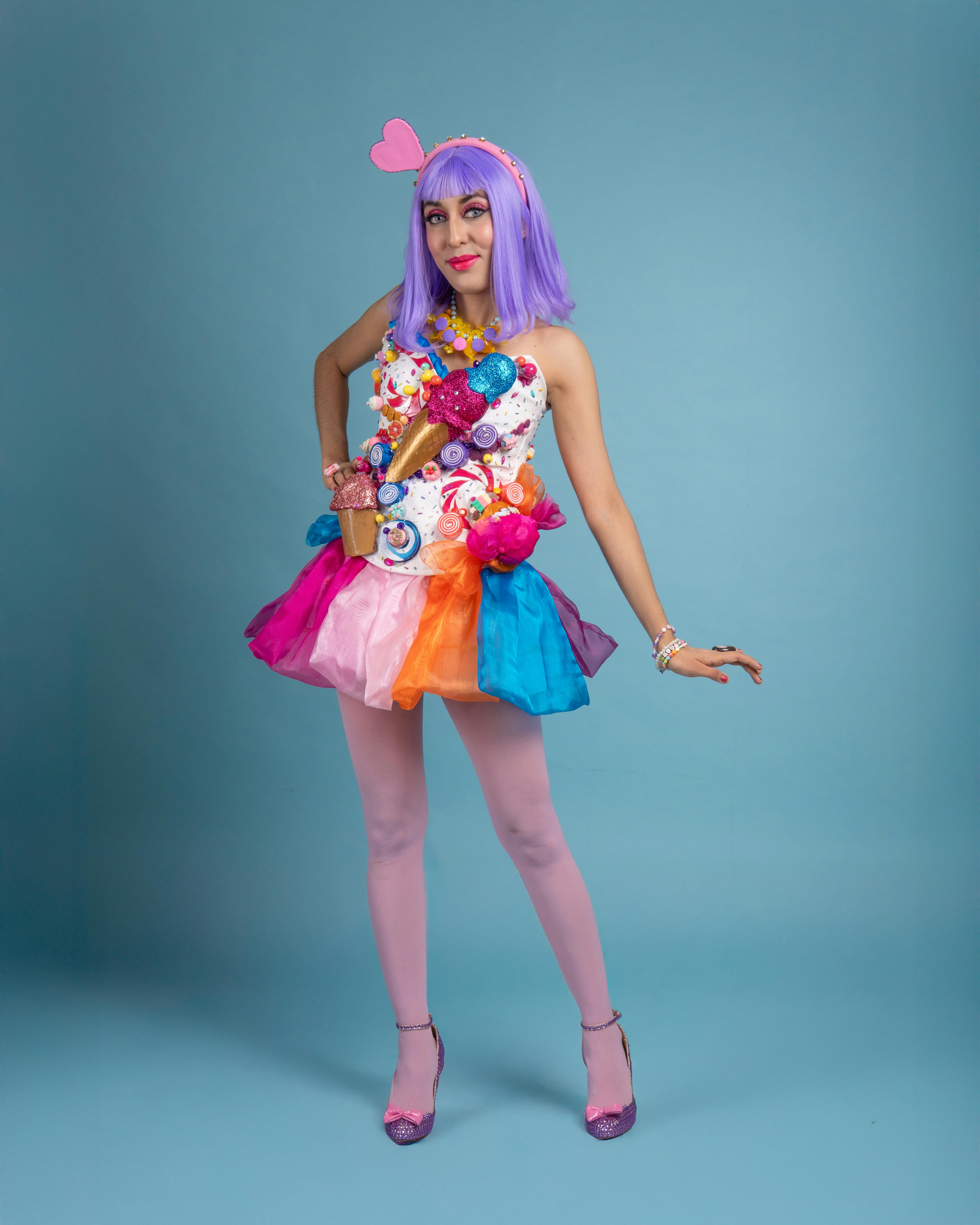 ingyenes Egy fiatal nő élénk cosplay-ruhában pózol kék háttér előtt. Stockfotó