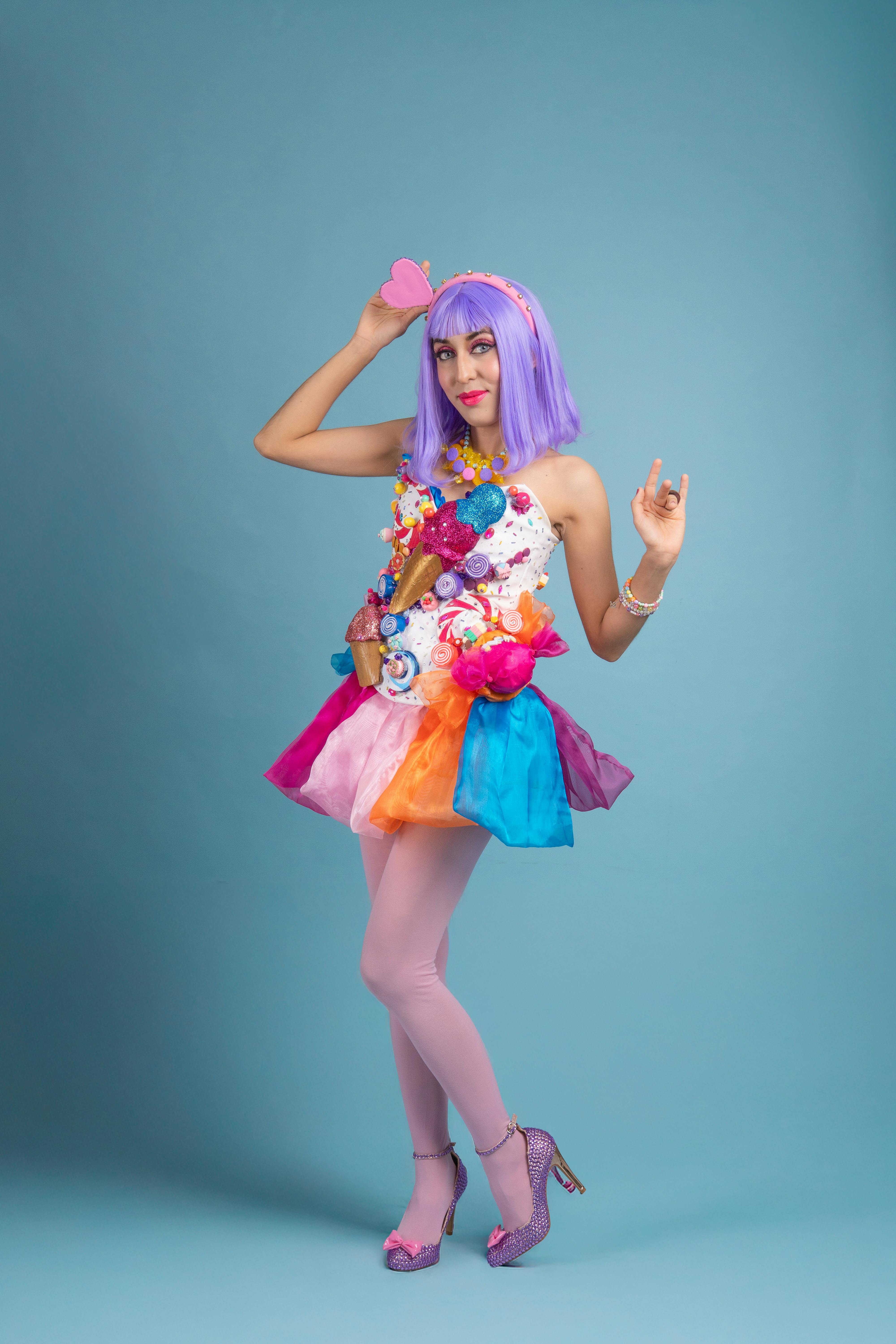 Zadarmo Módny cosplay portrét so žiarivým kostýmom a farebným pozadím. Fotka z fotobanky