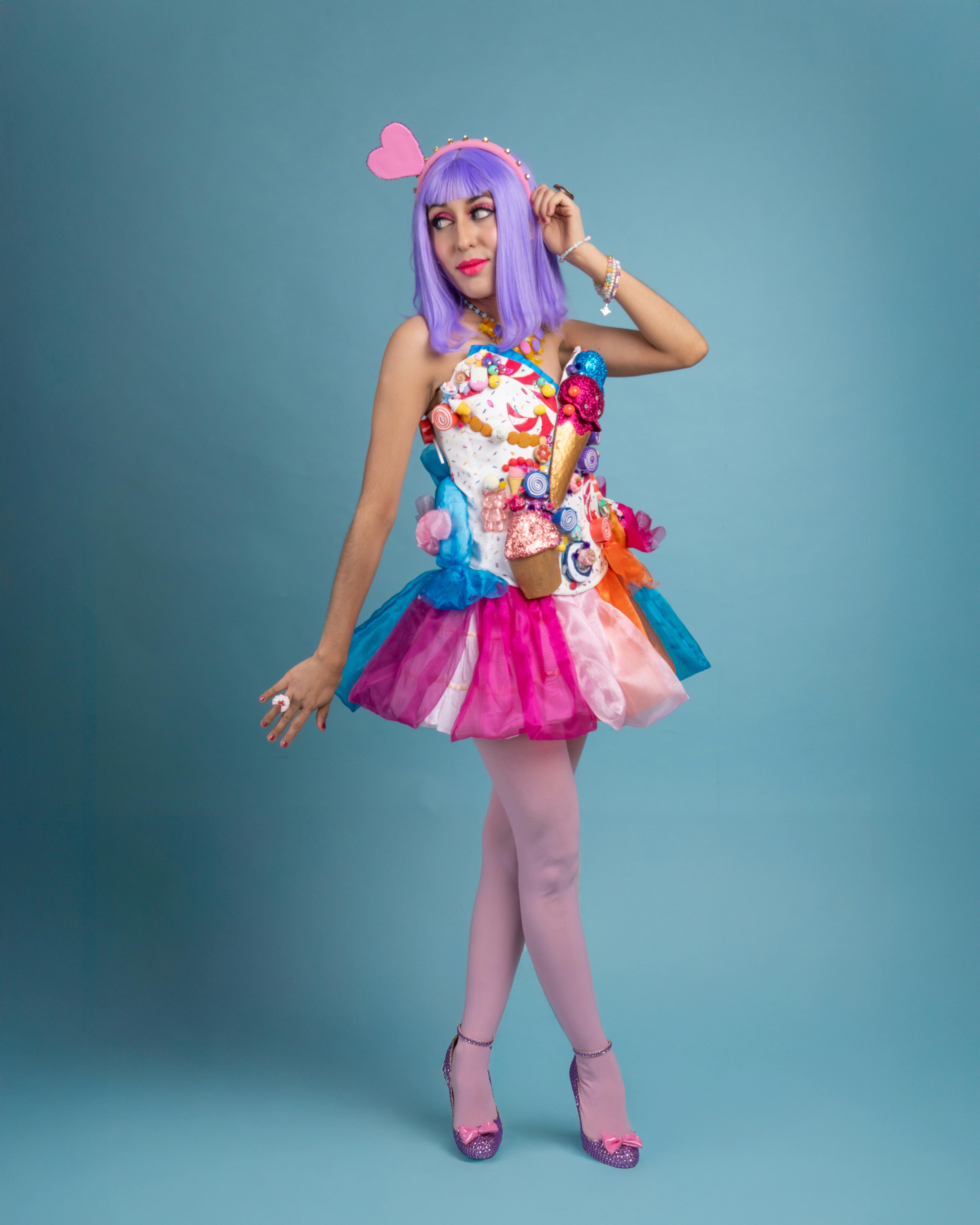 ingyenes Élénk cosplay, amelyben egy nő látható színes ruhában, lila parókával és szívkiegészítőkkel. Stockfotó