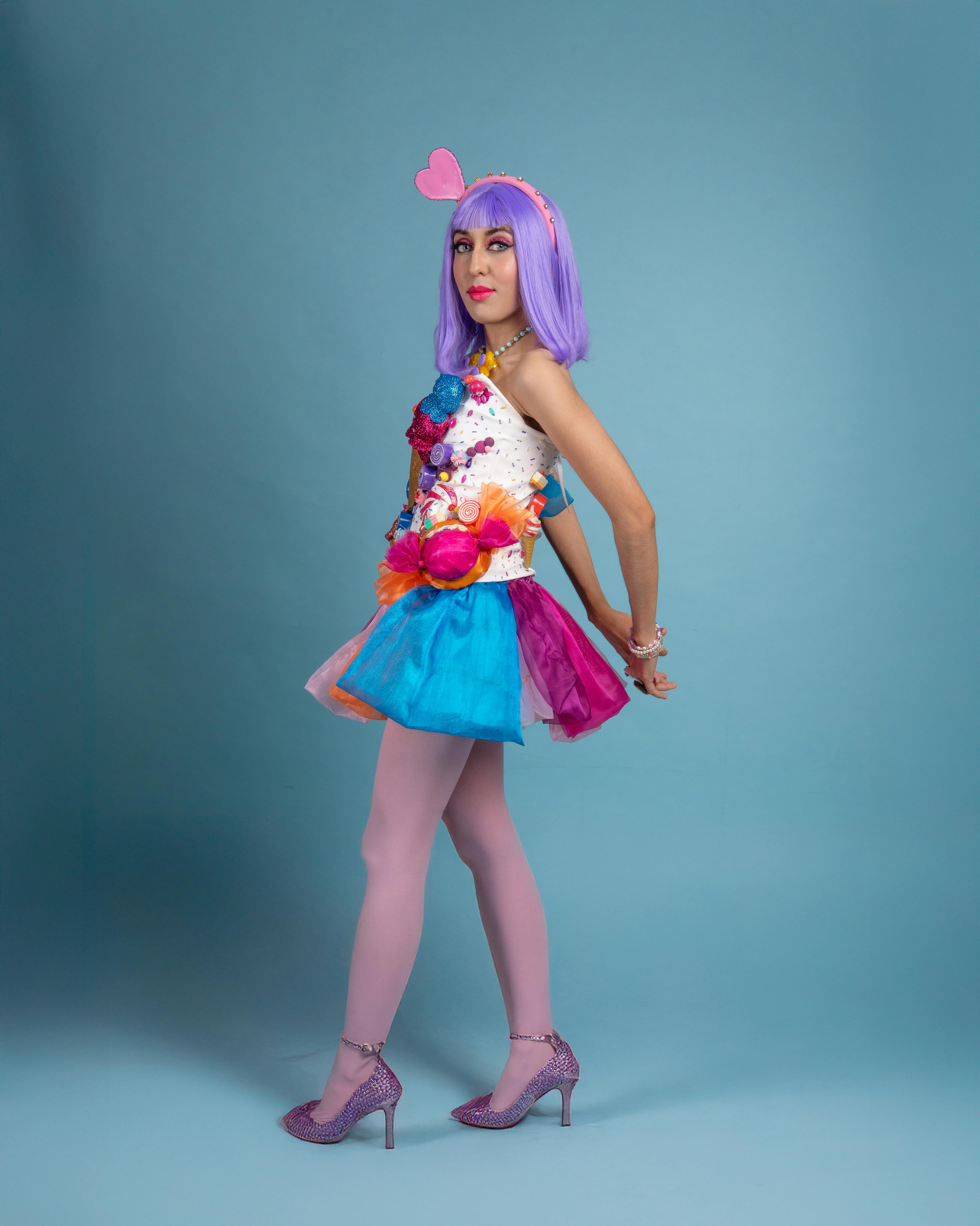 ingyenes Fiatal nő színes cosplay öltözékben pózol a kék háttér előtt. Stockfotó