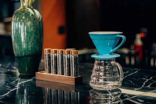 Free Stylish coffee brewing station featuring a V60 dripper and coffee bean samples. Stock Photo