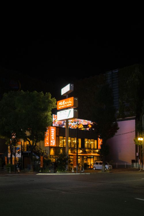 Free Illuminated city street in Fukuoka, Japan at night with vibrant signage and architecture. Stock Photo