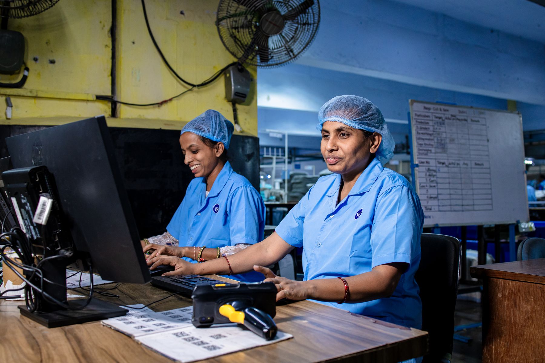 Indian factory workers working together at computers