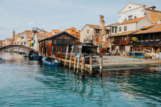 Charming Venetian canal scene with wooden boatyard and historic architecture.