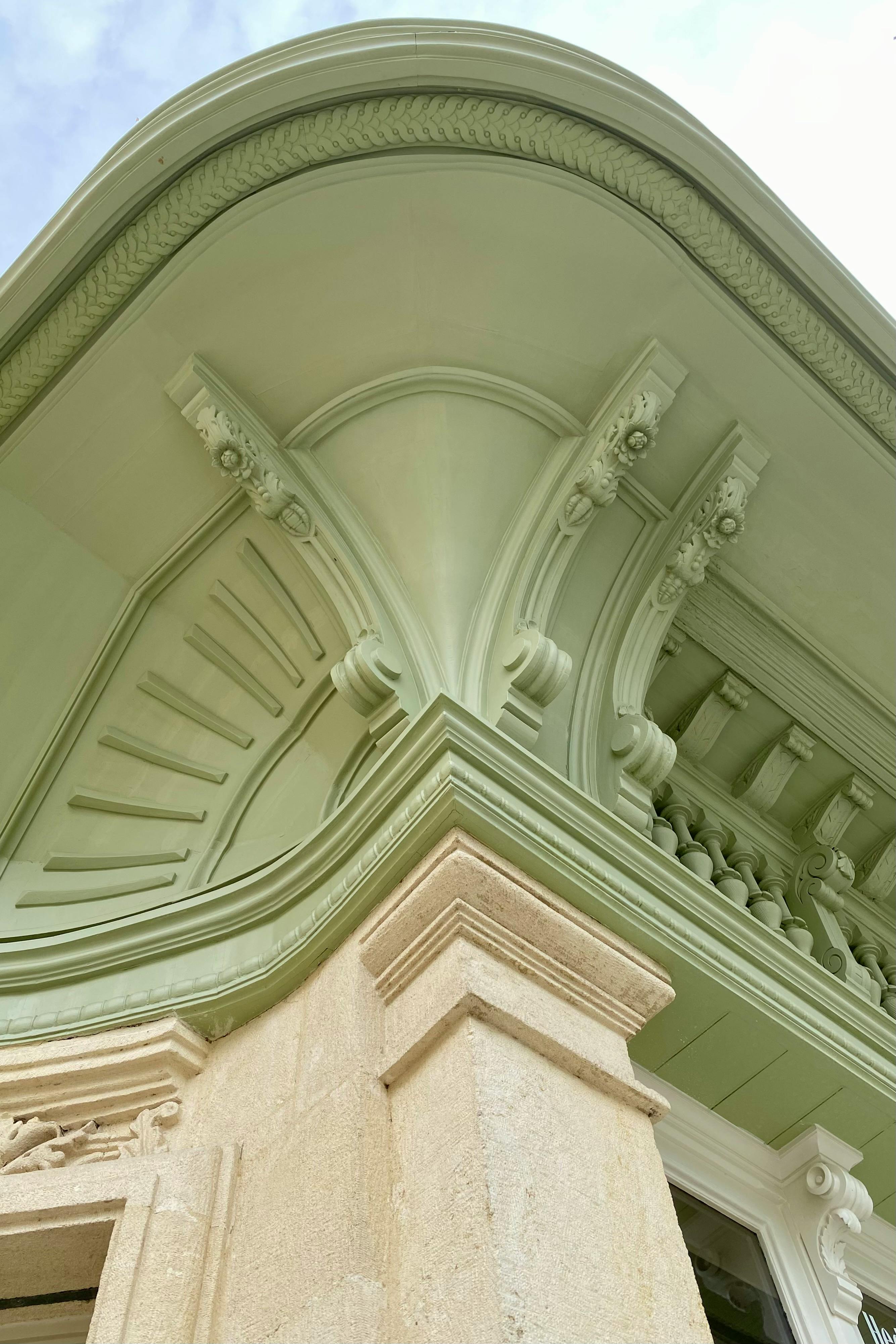 Free Close-up view of a classic architectural facade with intricate design elements and soft green tones. Stock Photo