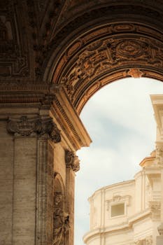 Close-up of a beautifully detailed architectural arch and building facade under a bright sky.