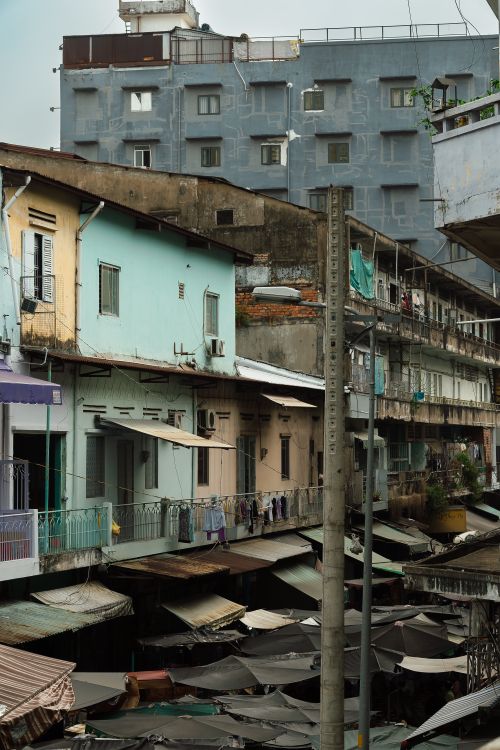 Free A dynamic view of weathered buildings and market stalls in an urban street setting. Stock Photo