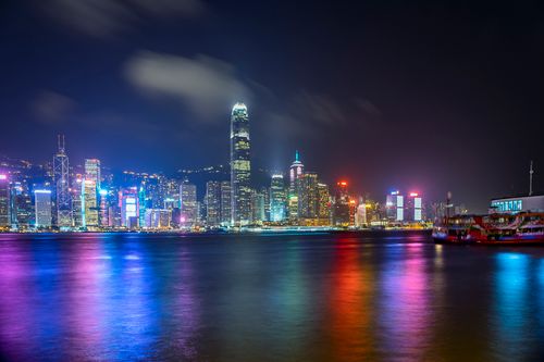 Free Captivating nighttime view of Hong Kong's illuminated skyline reflecting over the harbor. Stock Photo