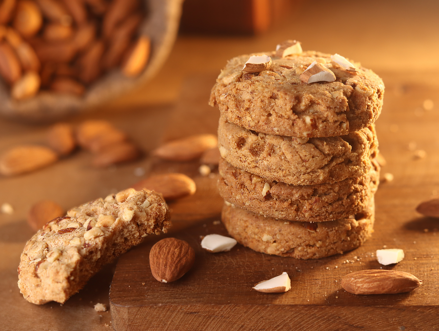 Stack of almond chocolate chip cookies on a rustic wooden surface
