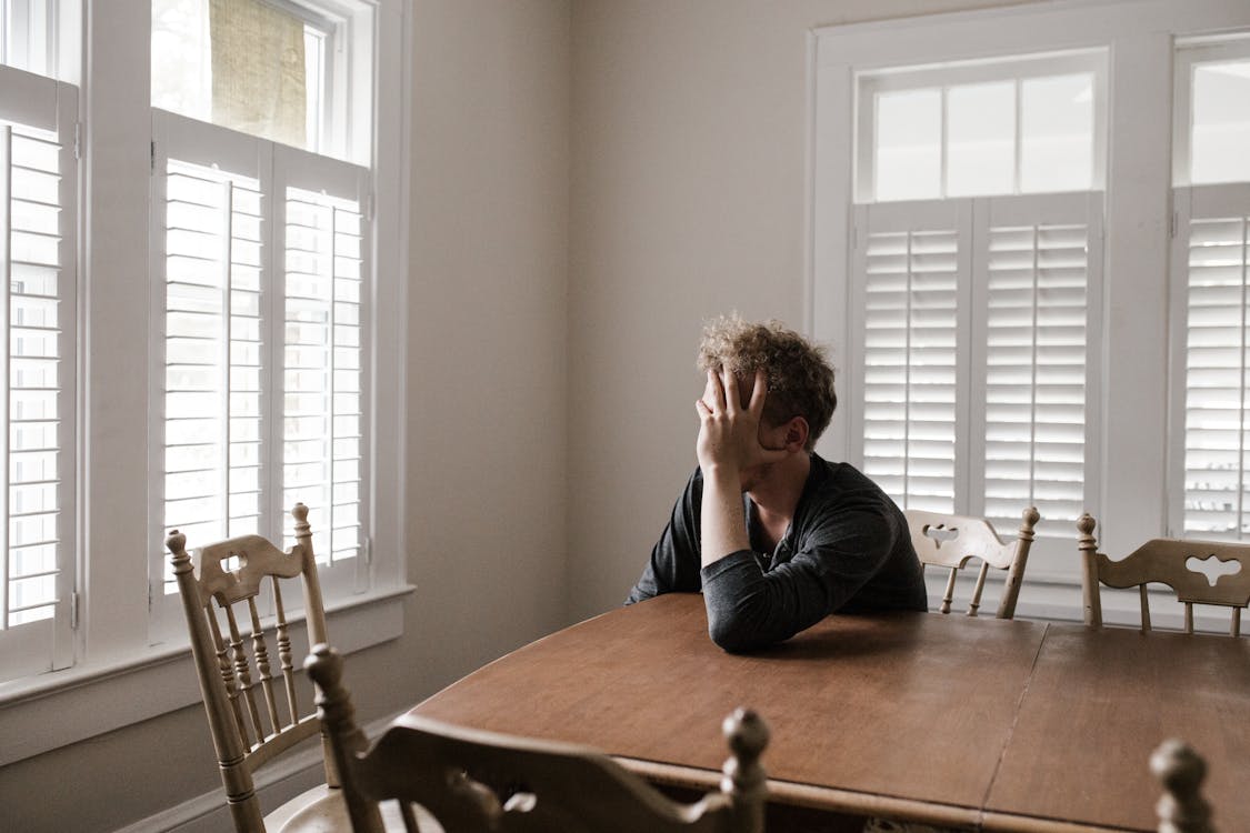 Foto Van Man Leunend Op Houten Tafel