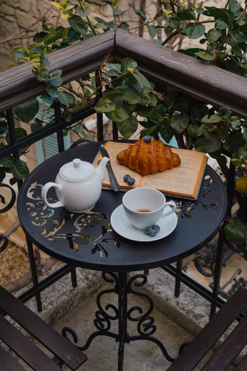 Free A cozy outdoor breakfast setting with tea, croissant and blueberries. Stock Photo