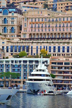 A stunning luxury yacht moored against the iconic architecture of Monaco's harbor.
