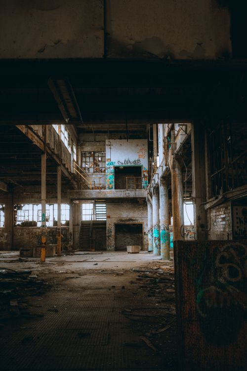 Free Explore the haunting beauty of an abandoned industrial building, showcasing decaying architecture and graffiti art. Stock Photo