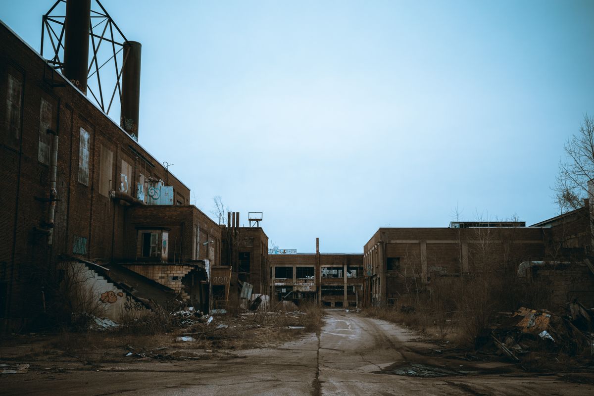 Atmospheric photograph of an abandoned industrial building in urban decay, similar in feeling to Hashima Island's silent skyline