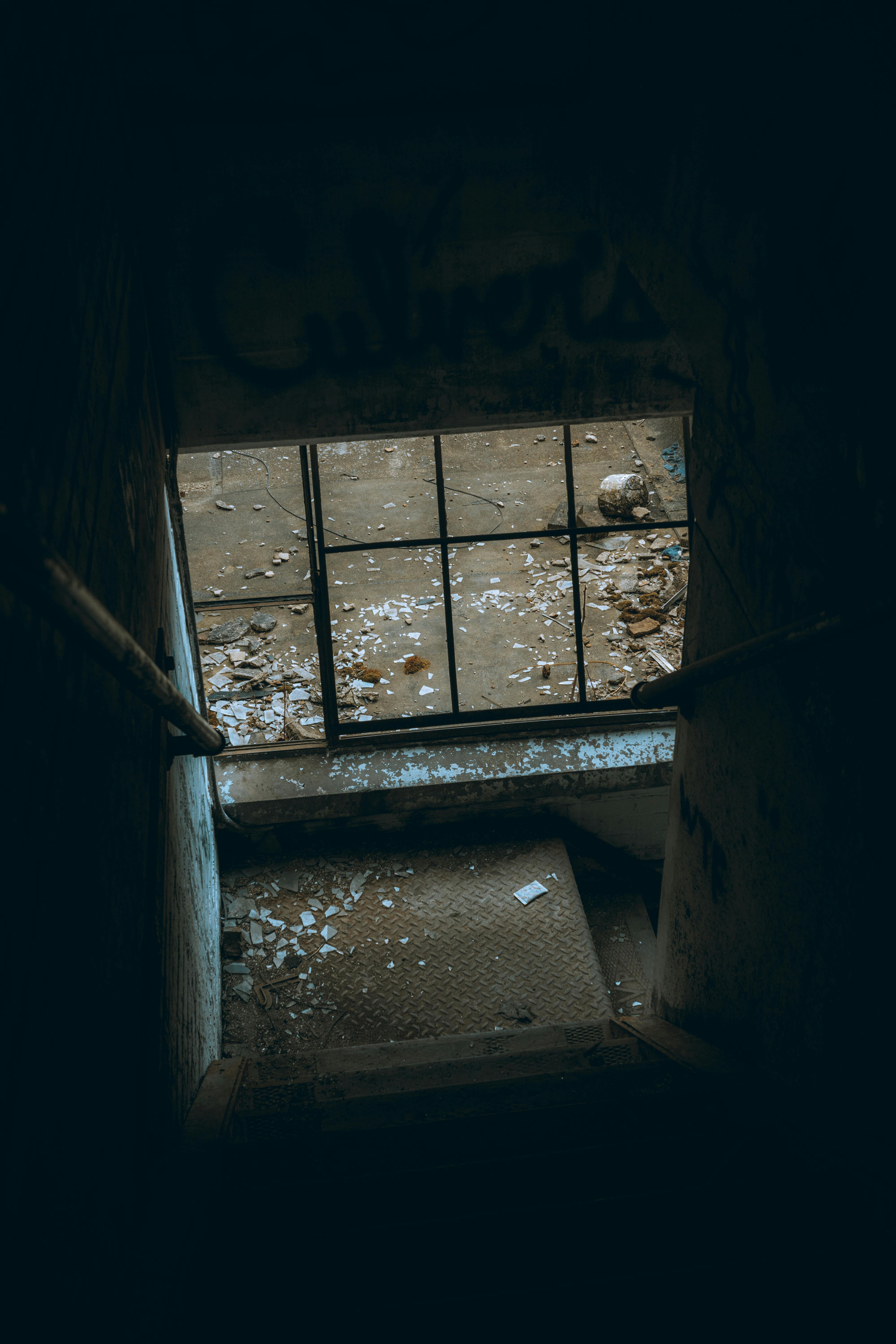 Kostnadsfria Kuslig vy av en dunkel trappa i en övergiven byggnad med skräp. Stock foto