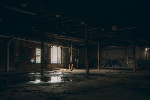 Free Explore the haunting beauty of an abandoned warehouse with graffiti and dim lighting. Stock Photo