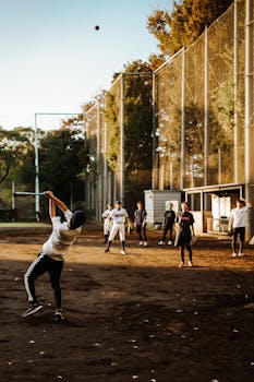 Group of people playing baseball in a sunlit park in Japan. Captures dynamic mid-swing action.