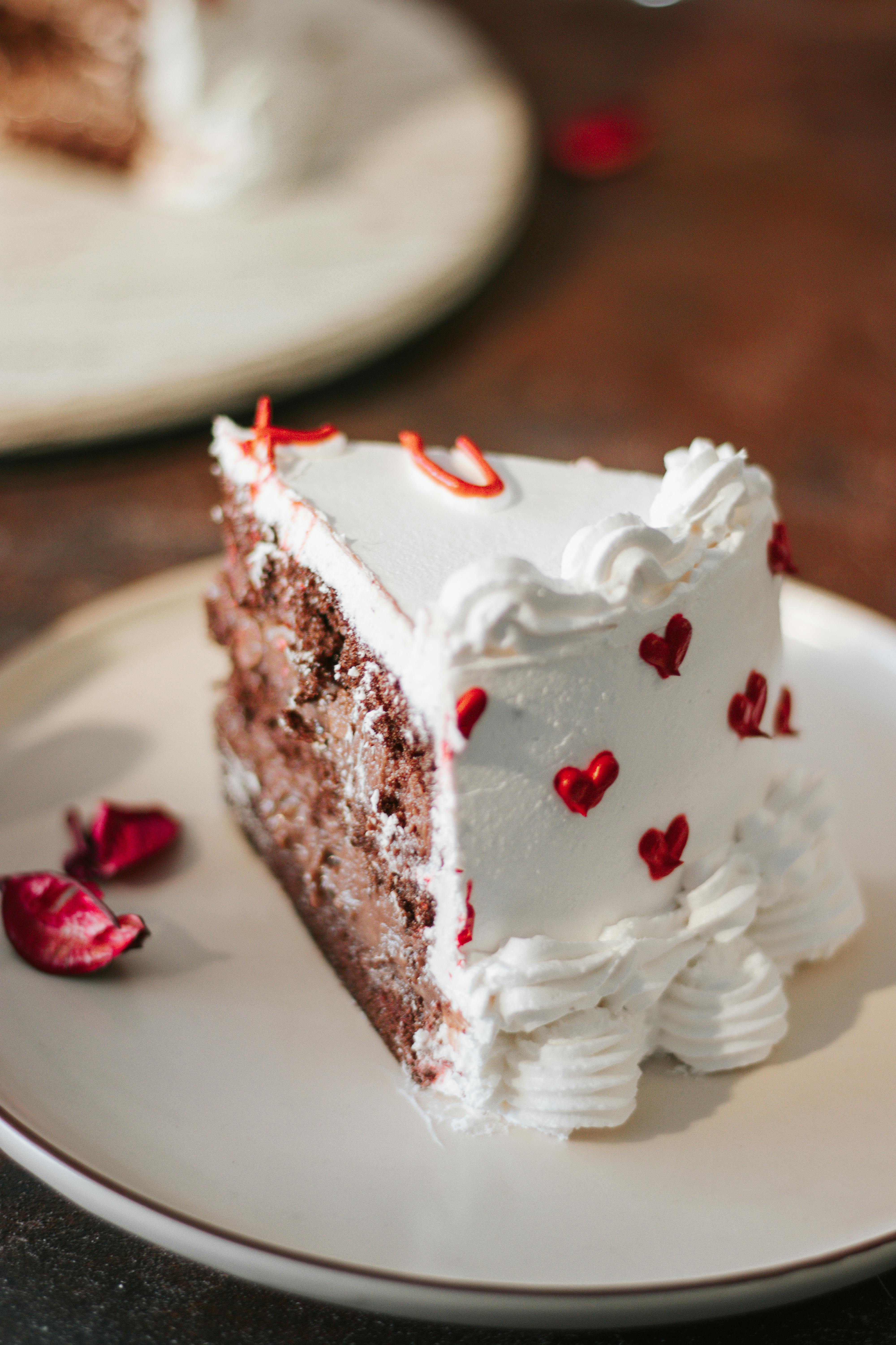 Indulge in a romantic slice of chocolate cake, beautifully decorated with red hearts.