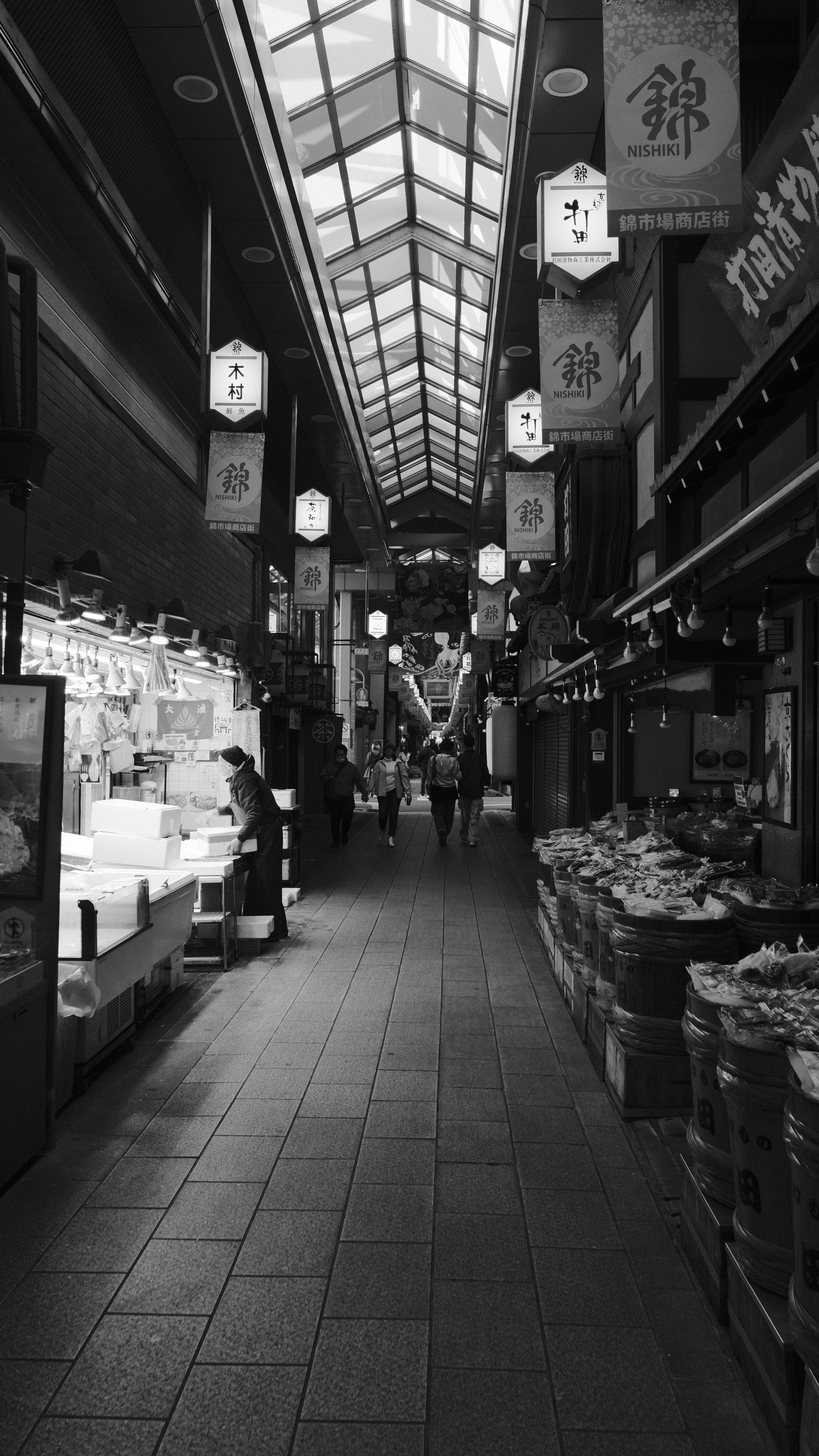 Nishiki Market bustling with morning shoppers under vibrant red lanterns and colorful shop awnings