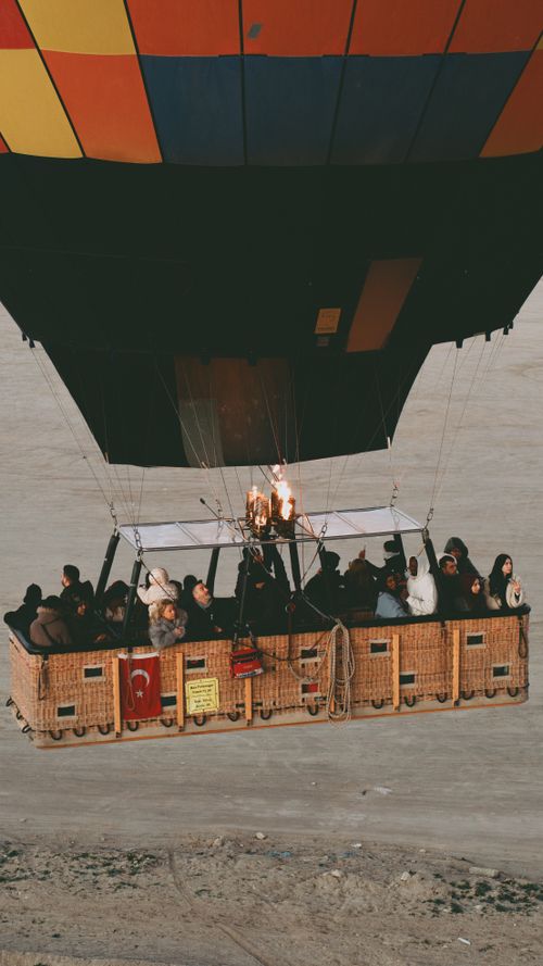 Free Hot air balloon with passengers flying over scenic landscape, aerial view. Stock Photo