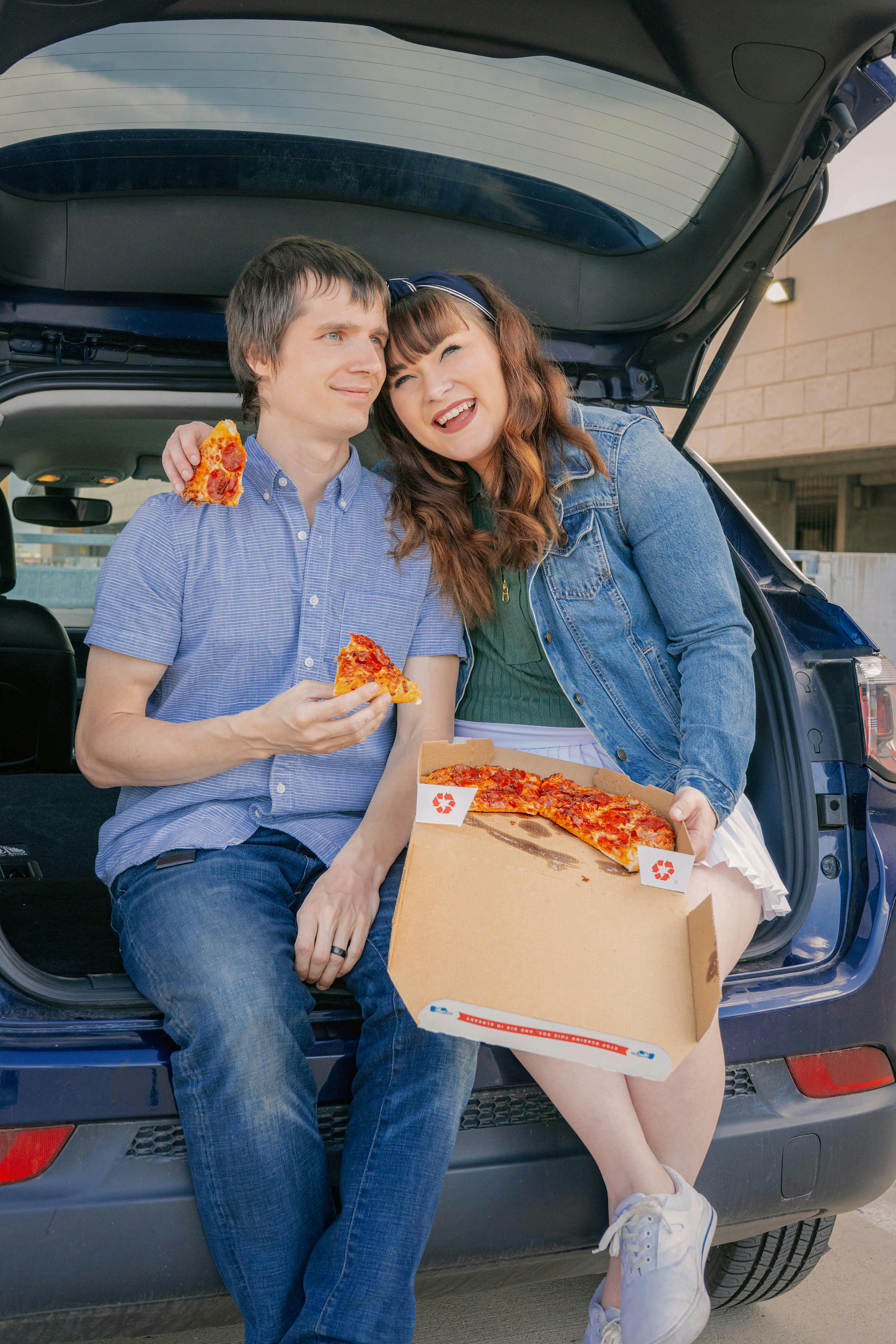 Free A joyful couple enjoying pepperoni pizza in the trunk of their car. Perfect for lifestyle images. Stock Photo