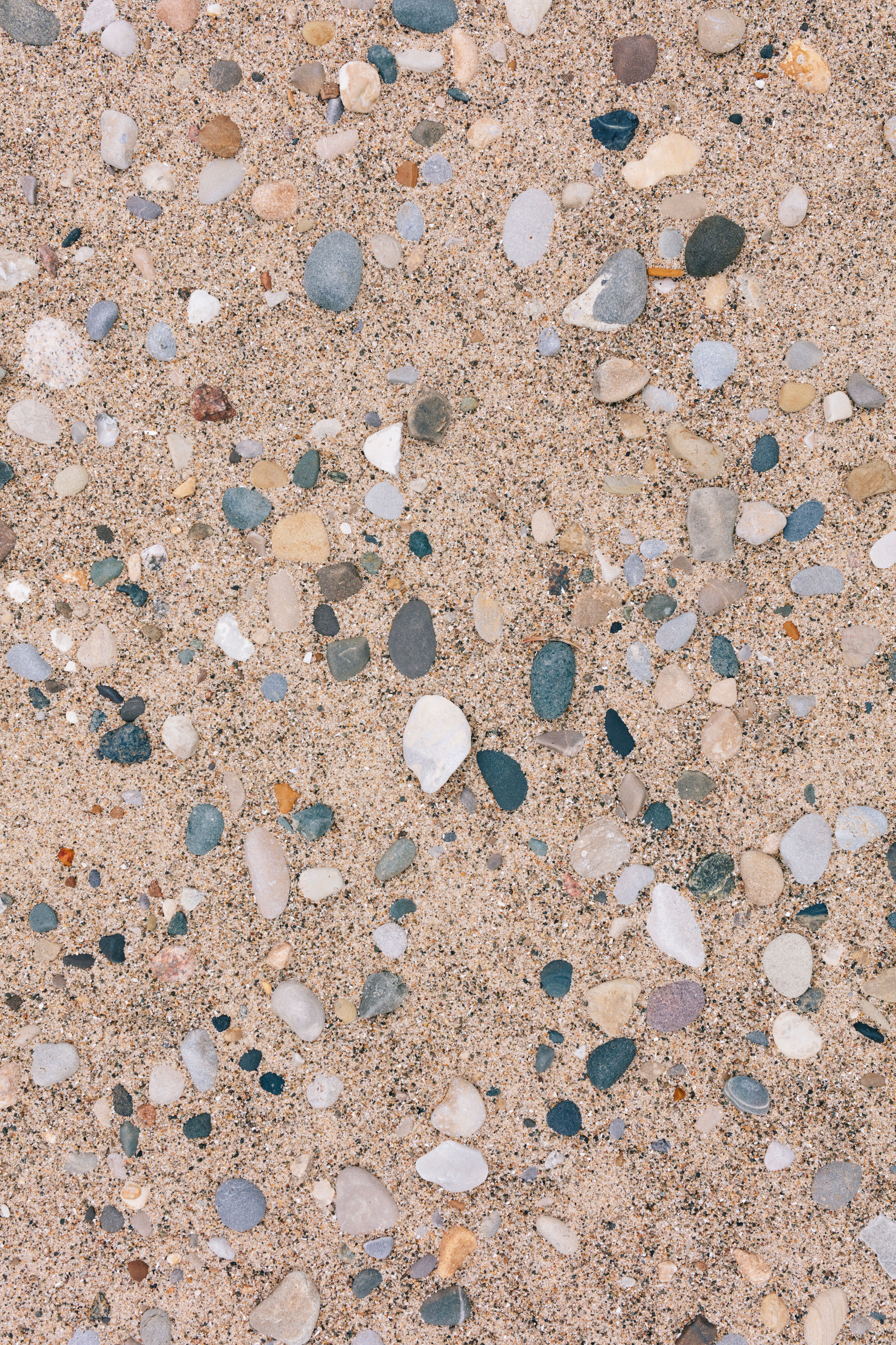 Close-Up of Colorful Pebbles on Sandy Surface · Free Stock Photo