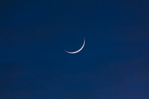 A serene crescent moon set against a deep twilight sky, offering a sense of tranquility and wonder.
