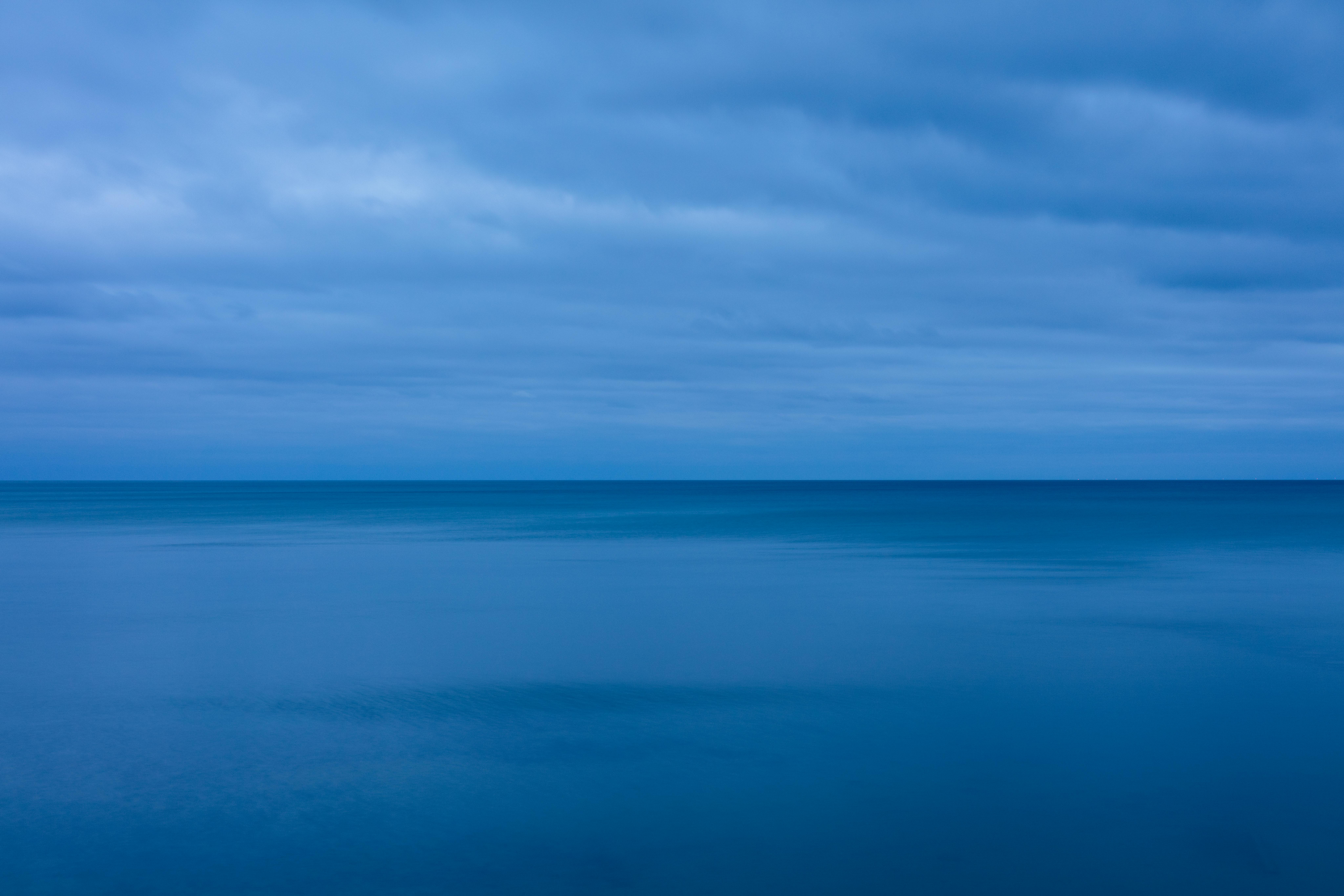 Serene twilight view of calm Lake Huron under a cloudy blue sky.