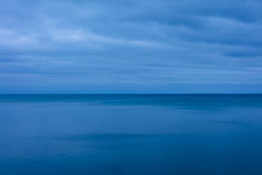 Serene twilight view of calm Lake Huron under a cloudy blue sky.