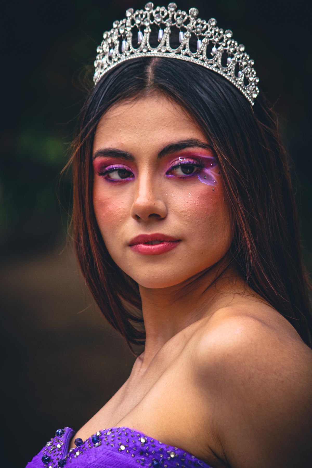 Niña con disfraz de princesa morado, corona y maquillaje creativo