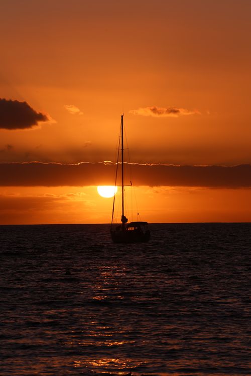 Free Peaceful sailboat silhouette during a stunning sunset at sea, captured off the Spanish coast. Stock Photo