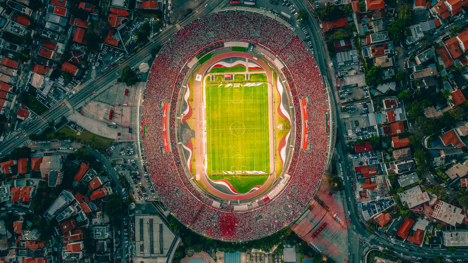 Vibrant aerial shot of a packed football stadium with panoramic cityscape.