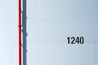 Minimalist Image of Red Pipe on White Wall