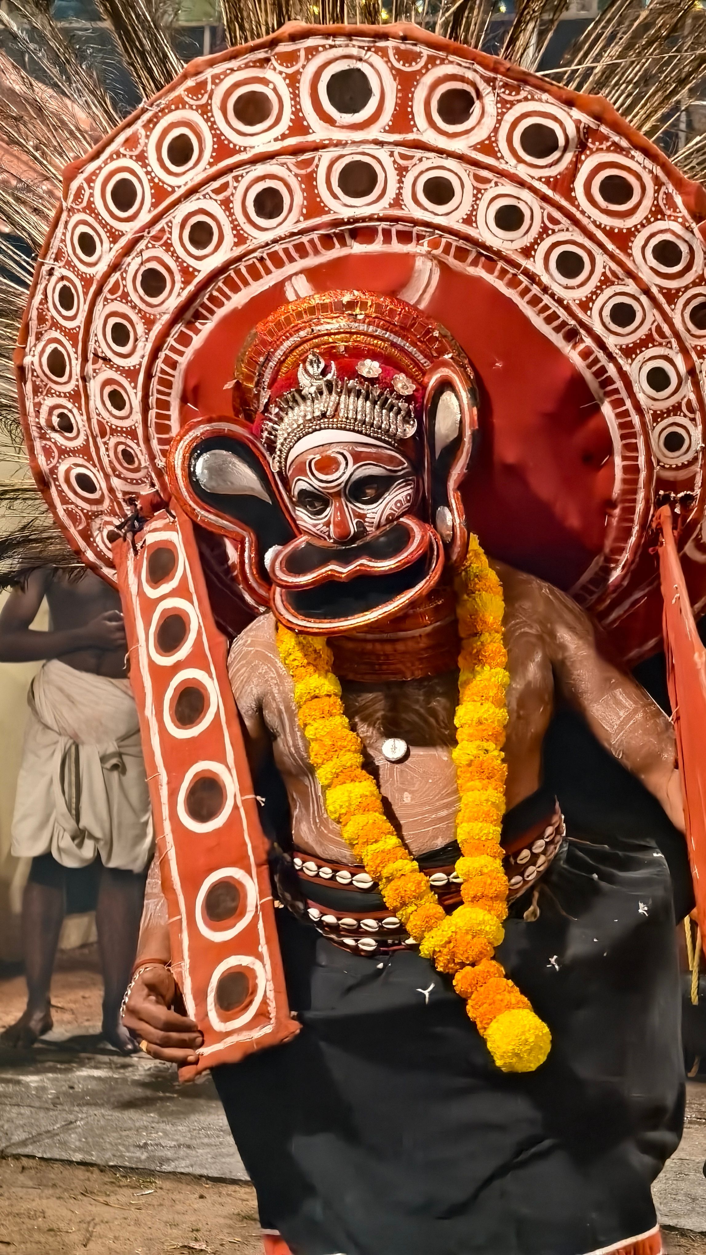 Colorful Theyyam performer with traditional costume and face painting, Kerala, India.