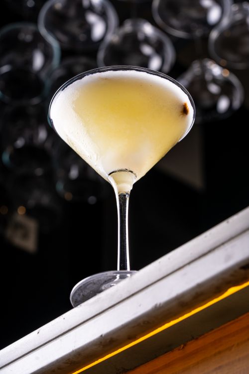 Free Close-up of a frothy lemon cocktail in a martini glass on a bar counter. Stock Photo