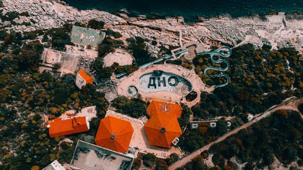 Aerial photo showing an abandoned water park on Antalya's coast with unique structures and vivid colors.