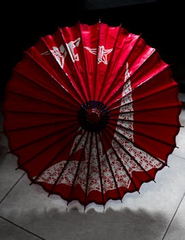 Red Japanese umbrella adorned with crane origami and patterns in Buenos Aires.