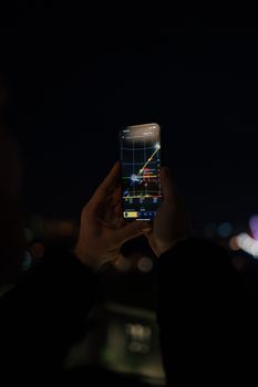 Person exploring constellations using a stargazing app on a smartphone at night.