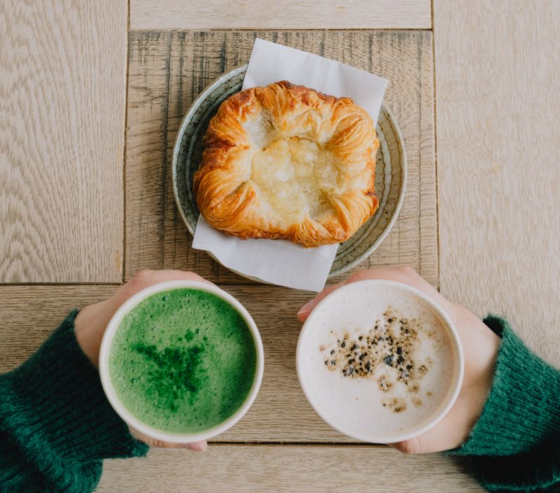 Enjoy a cozy Japanese café breakfast with a foamy matcha latte and flaky pastry delight.