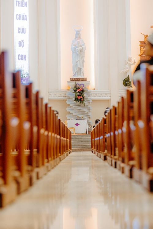 Free Beautiful church interior featuring a marble statue and wooden pews. Stock Photo