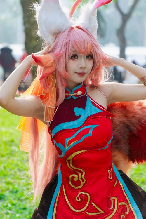 Free Cosplayer in elaborate red costume with ears and tail outdoors in the park. Stock Photo