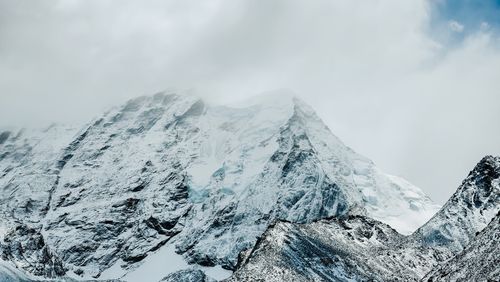 Free Stunning view of a snow-covered mountain peak with clouds shrouding the summit. Stock Photo