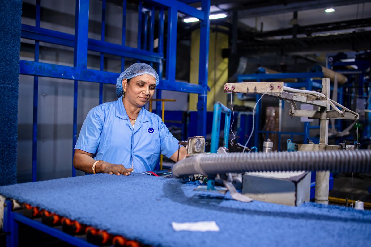 Indian textile factory worker operating machinery · Free Stock Photo