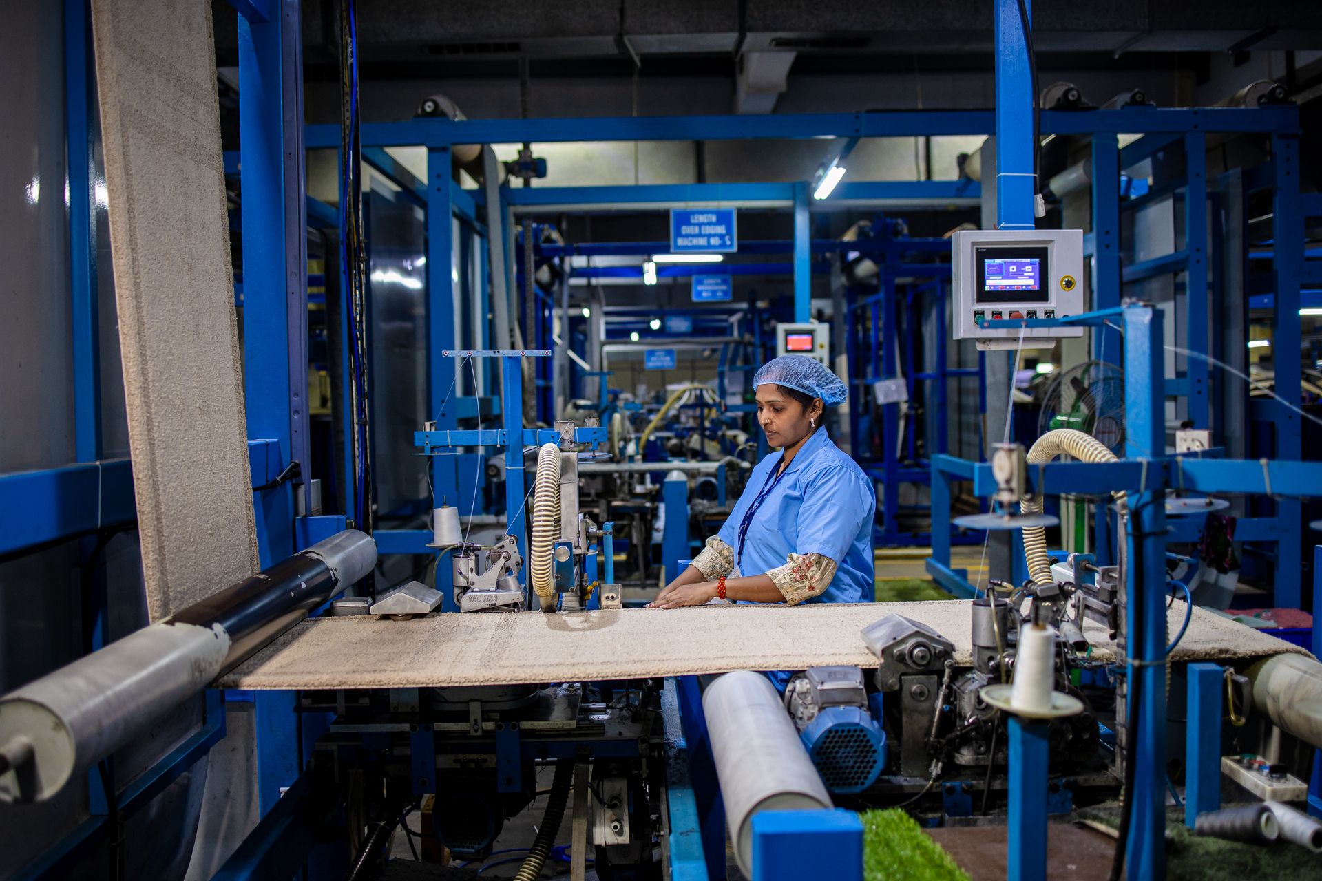 A textile factory worker operates machinery with precision, demonstrating industrial efficiency.