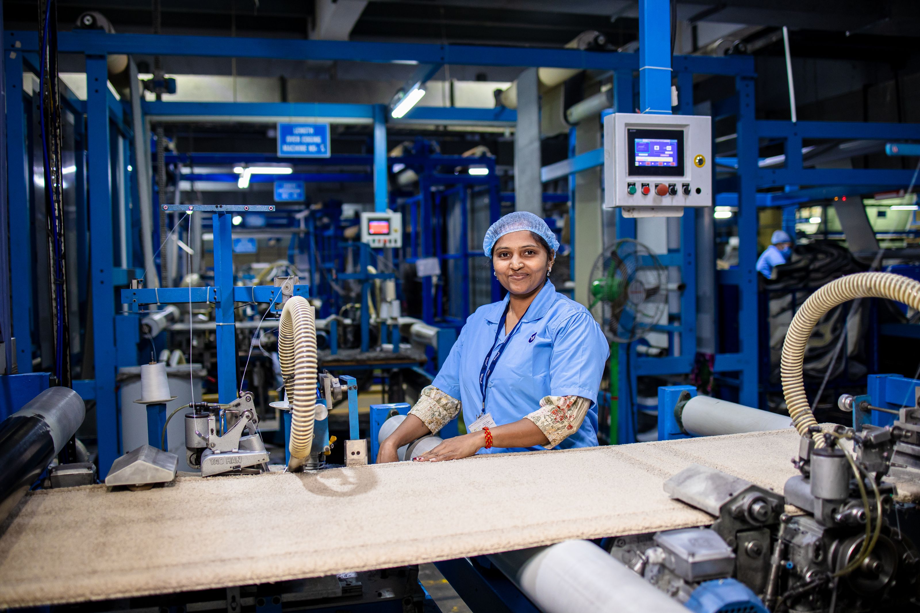 Smiling female worker in a modern textile factory, showcasing the industrial workspace.