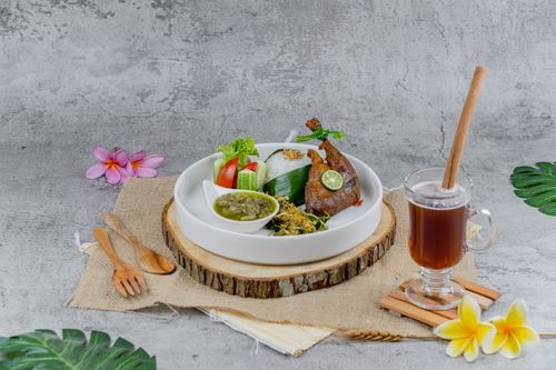Free Authentic Indonesian dish with sambal, rice, and herbal tea served indoors. Stock Photo