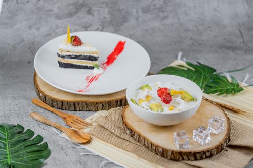 Free A decorative display featuring a chocolate layered cake and a bowl of tropical fruit salad with vibrant presentation. Stock Photo