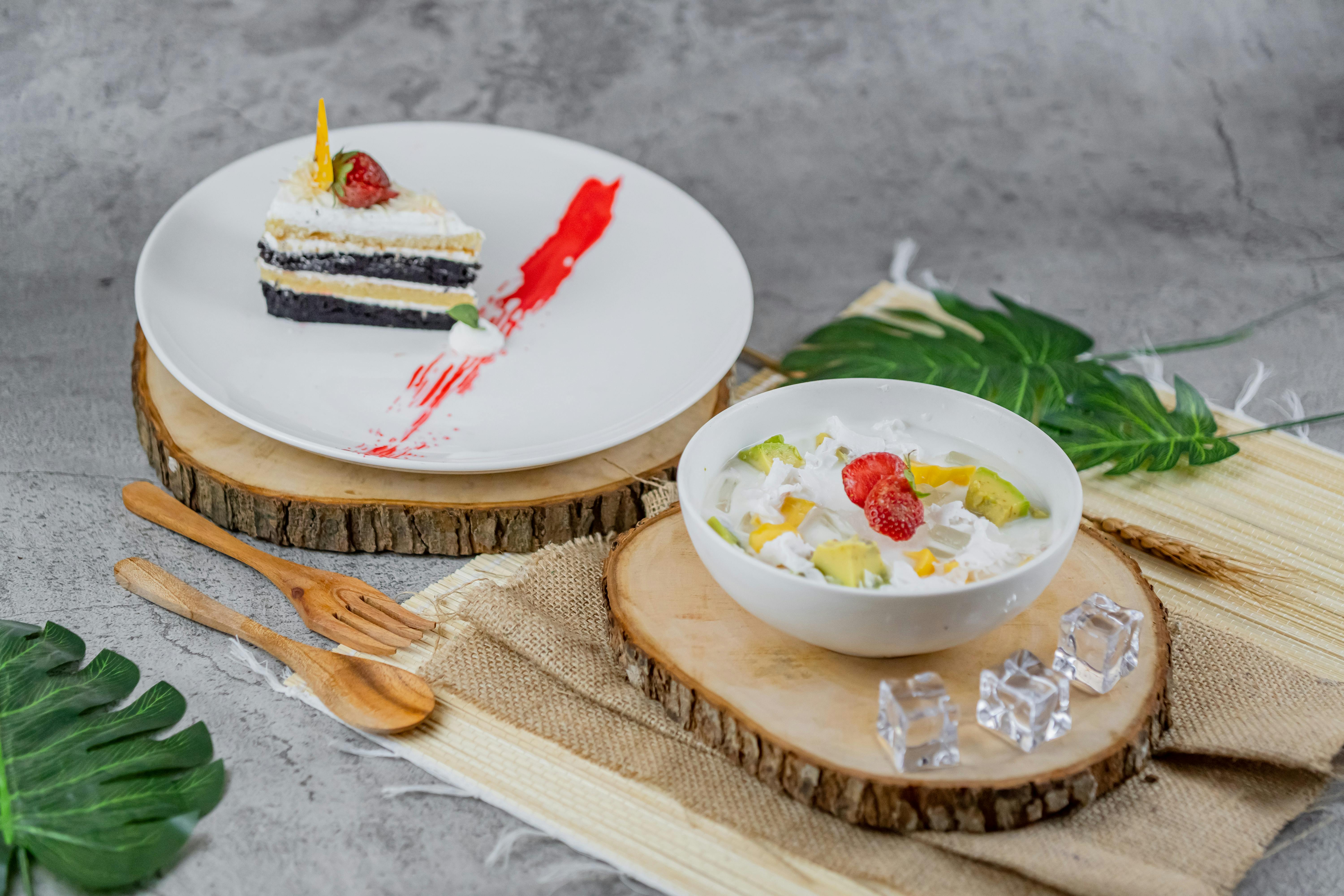 A delectable slice of cake alongside a colorful fruit salad, perfect for dessert lovers.