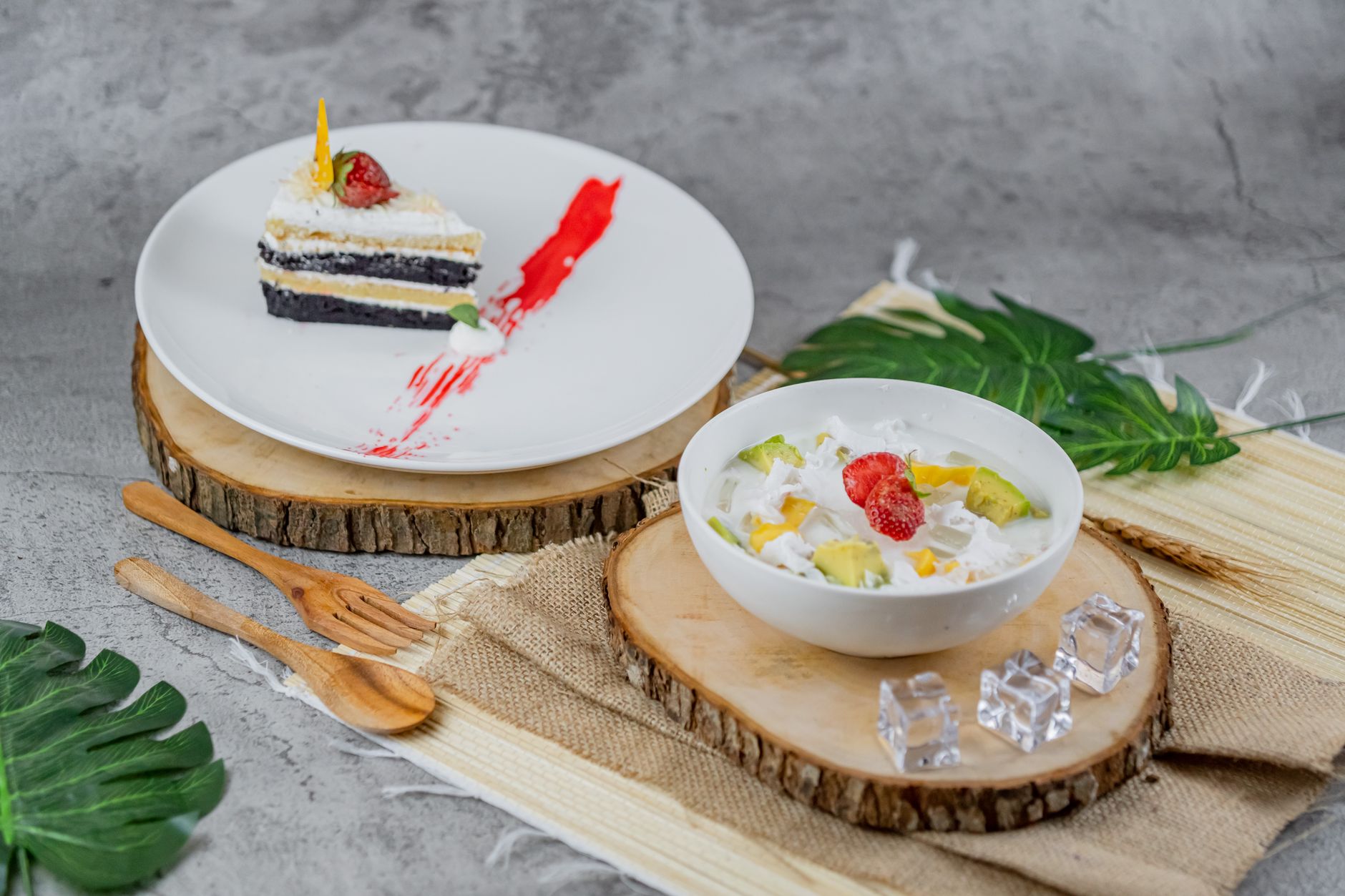A delectable slice of cake alongside a colorful fruit salad, perfect for dessert lovers.